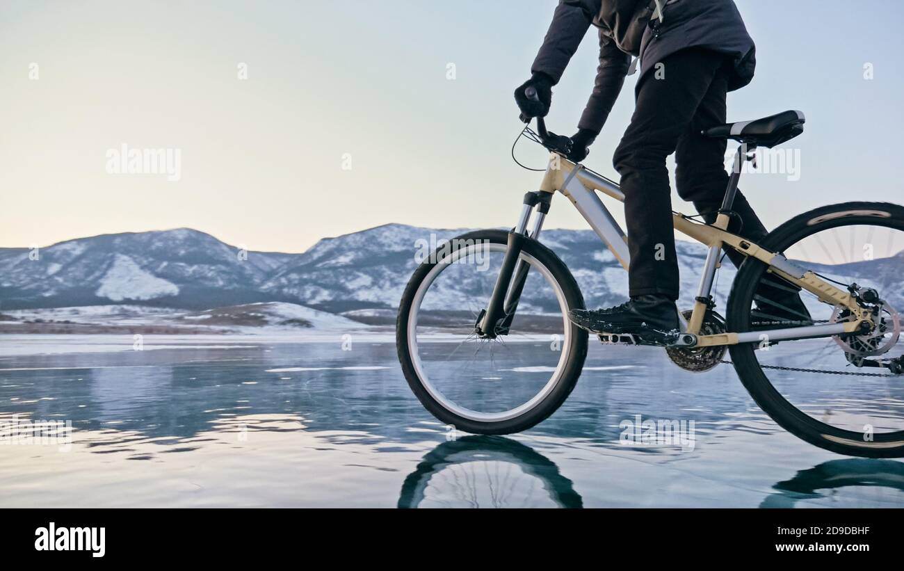 Der Mann fährt mit dem Fahrrad auf dem Eis. Eis des gefrorenen Baikalsee. T-Stück Stockfoto