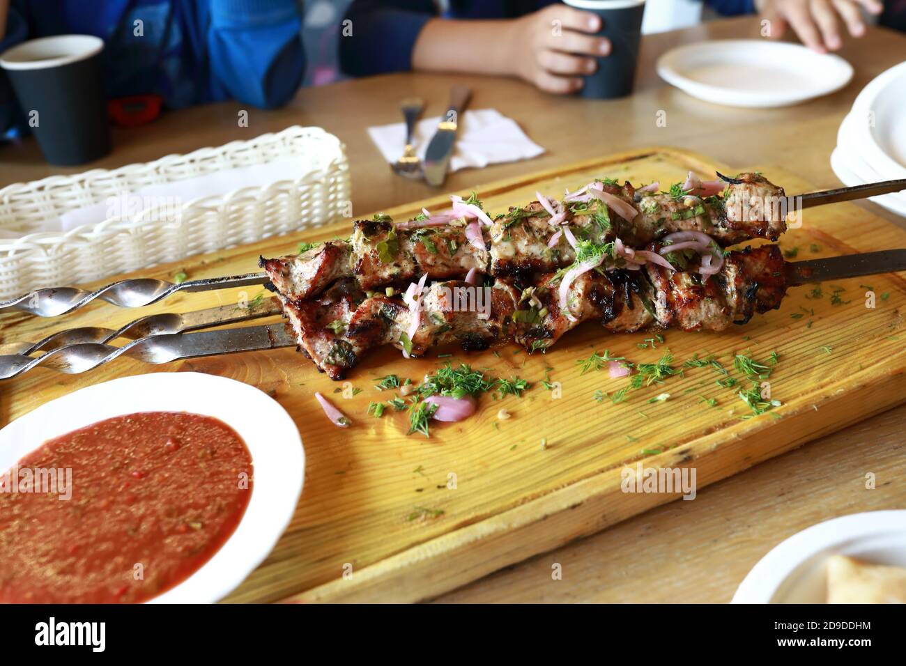 Schweinekebab auf Spieße auf Holzbrett im Restaurant Stockfoto