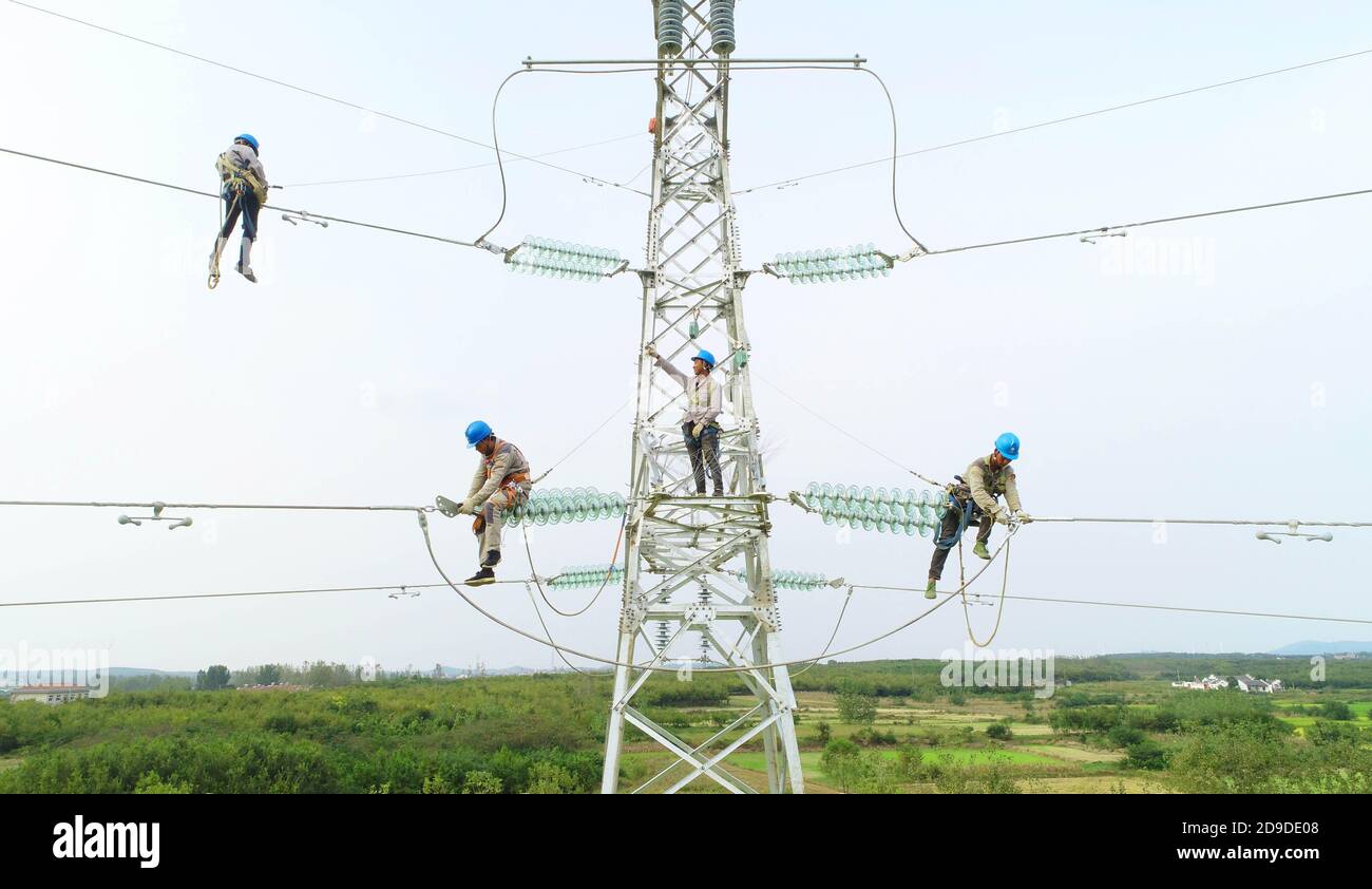 Elektroarbeiter installieren Zubehör an der Übertragungsleitung  Zhangguang-Tanchong, 50 Meter über dem Boden in Zhangguang Town, Bezirk  Nanqiao, C Stockfotografie - Alamy