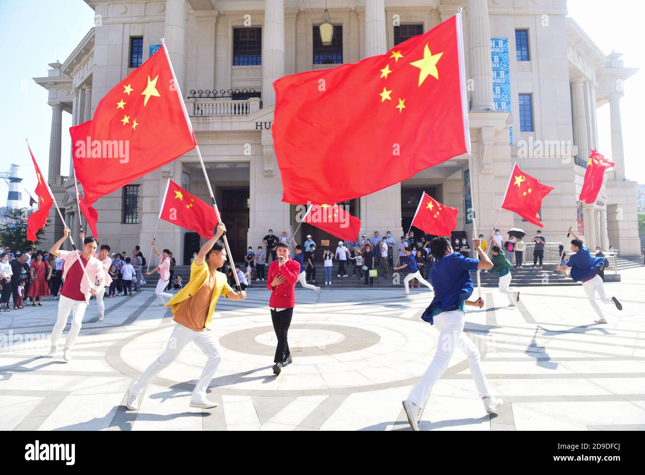 Menschen halten chinesische Flaggen auf der Welt des Films der Brüder Huayi in Suzhou, der ostchinesischen Provinz Jiangsu, 2. Oktober 2020. Stockfoto