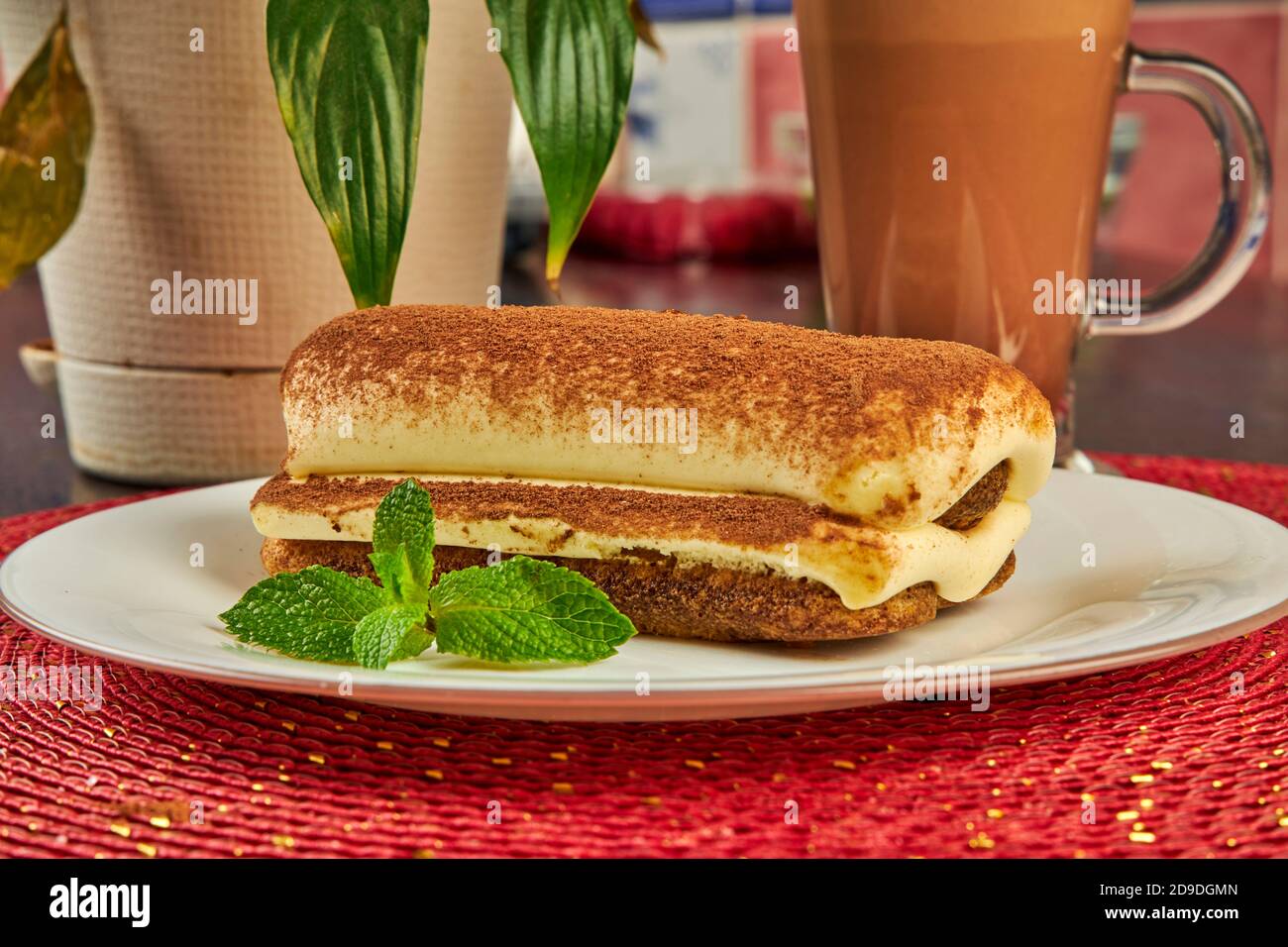 Ein Stück Biskuitkuchen und eine Tasse heißen Kaffee Auf dem Tisch Stockfoto