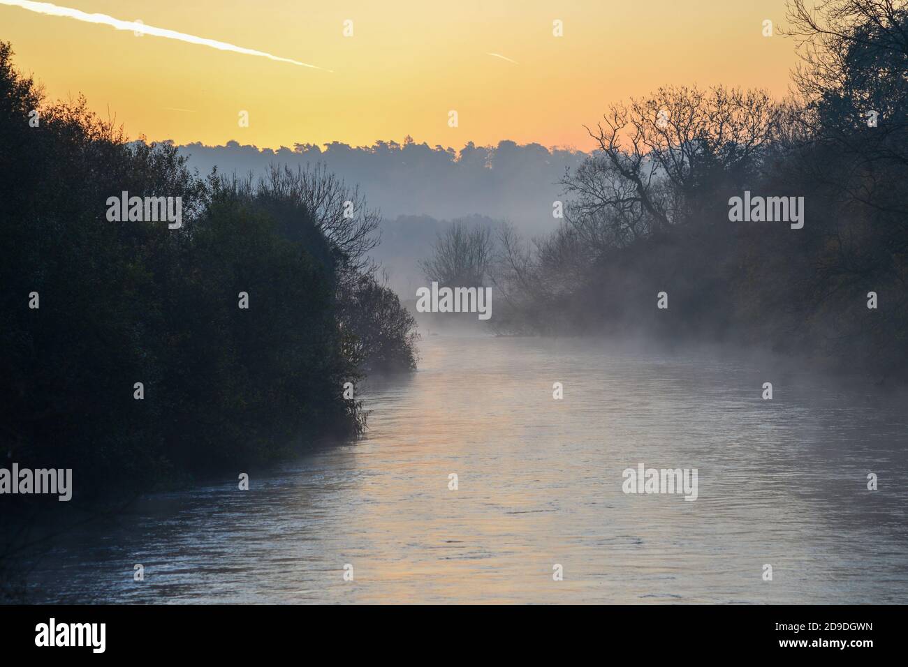 Kalter, frostiger, nebeliger Morgen mit warmorangenem Sonnenaufgang über Flusswasser, Fluss Avon, Avon Valley, Fordingbridge, New Forest, Hampshire, Großbritannien, 5. November 2020, Wetter, Landschaft. Stockfoto