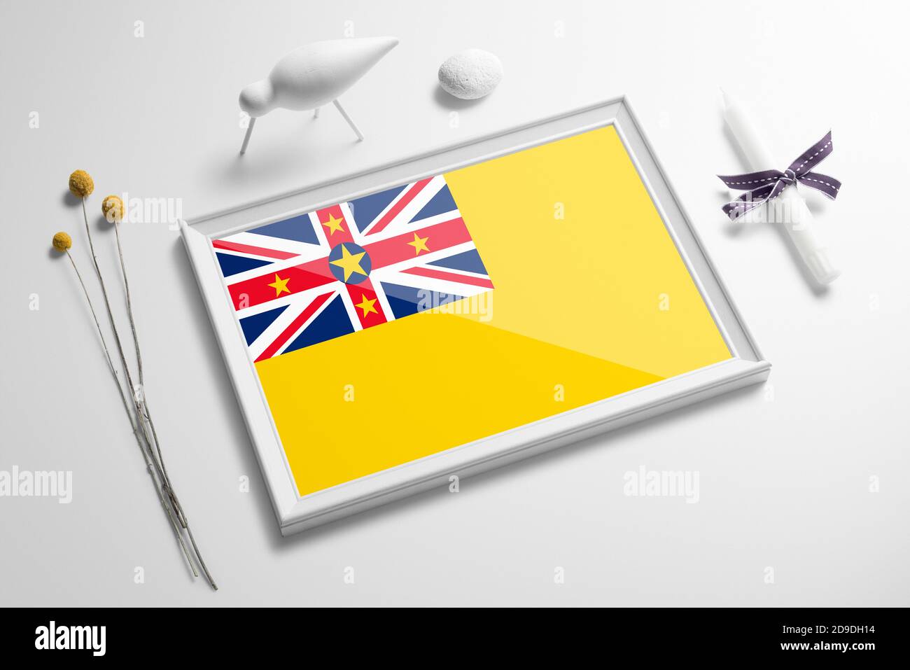 Niue Flagge in Holzrahmen auf Tisch. Weißes natürliches weiches Konzept, nationale Feier Thema. Stockfoto