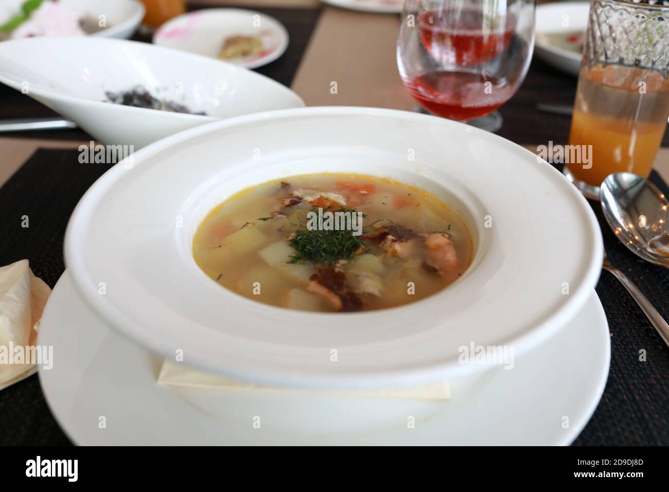 Schüssel mit geräucherter Fischsuppe mit Forelle und Hechtbarsch Im Restaurant Stockfoto