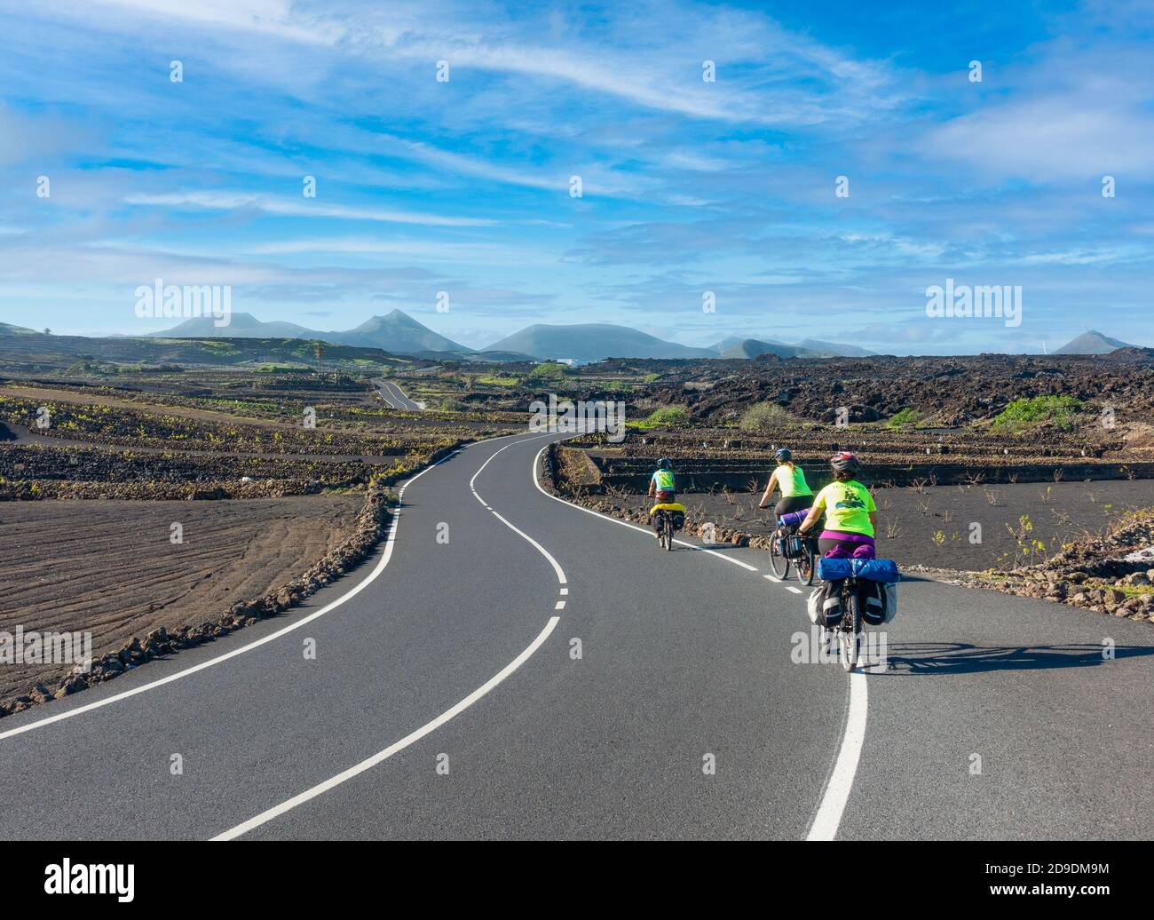 Drei Bikepackerinnen fahren durch den Timanfaya-Nationalpark auf Lanzarote, den Kanarischen Inseln, Spanien Stockfoto