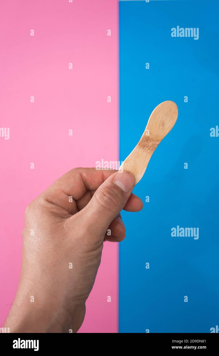 Hand hält eine Schokolade und Minze Eis, mit zwei Farben, blau und rosa Hintergrund. Stockfoto