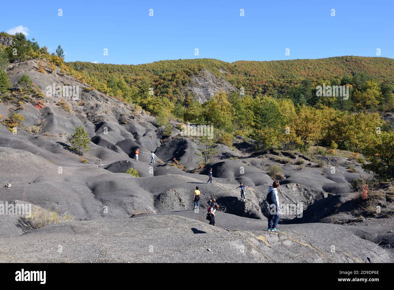 Kinder spielen auf Black Marl Formationen bekannt als Robines in Der Geopark der Haute Provence bei Digne-les-Bains Alpes-de-Haute-Provence Frankreich Stockfoto