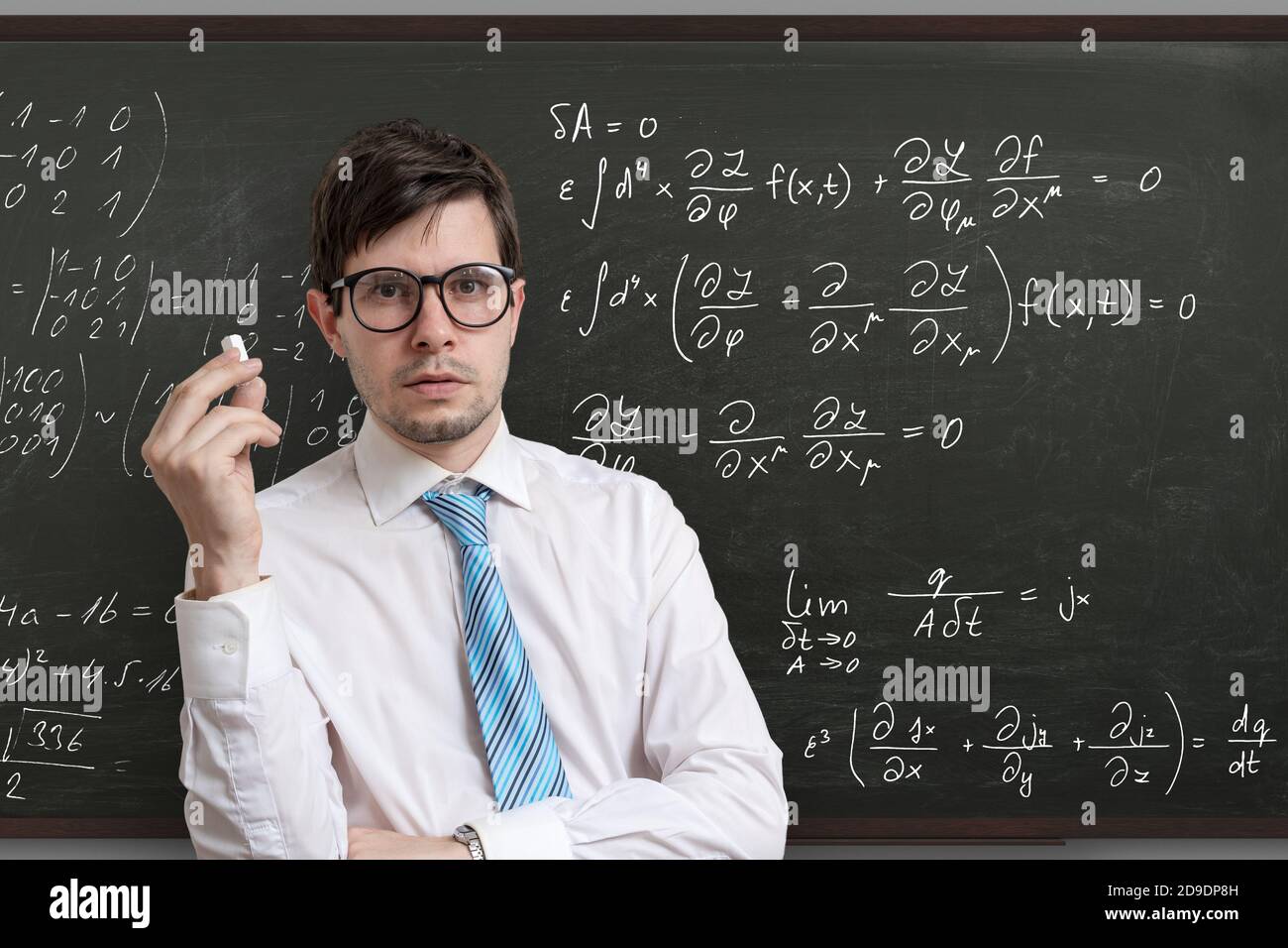Junge Lehrerin vor der Tafel mit mathematischen Gleichungen. Stockfoto