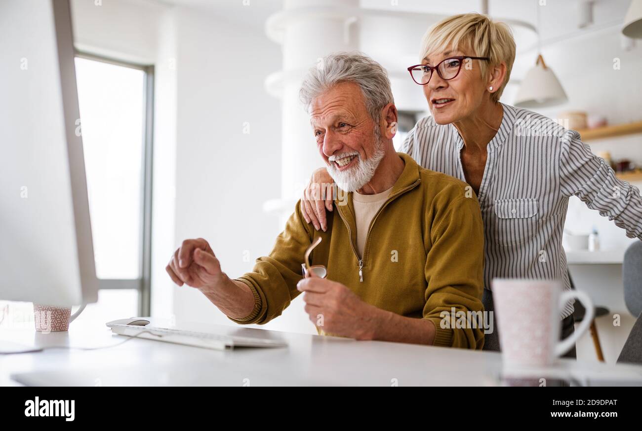 Ältere pensionierte Paare erfahren mehr über Computer- und Online-Support. Stockfoto