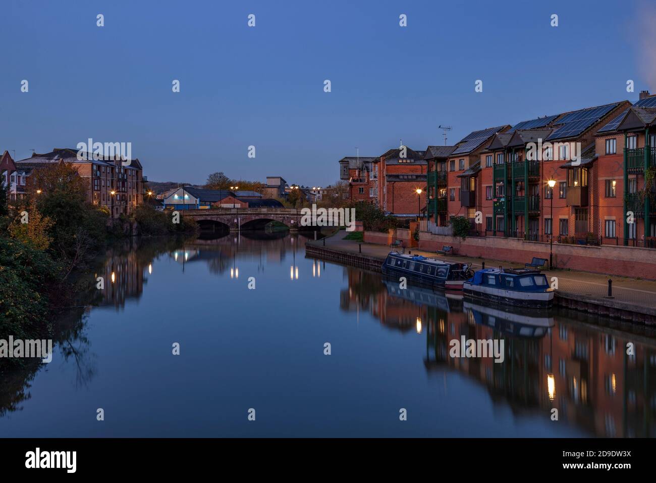 Apartments entlang des Flusses Nene mit Reflexionen im Wasser vor der Dämmerung, Stadtzentrum, Northampton, England, Großbritannien. Stockfoto