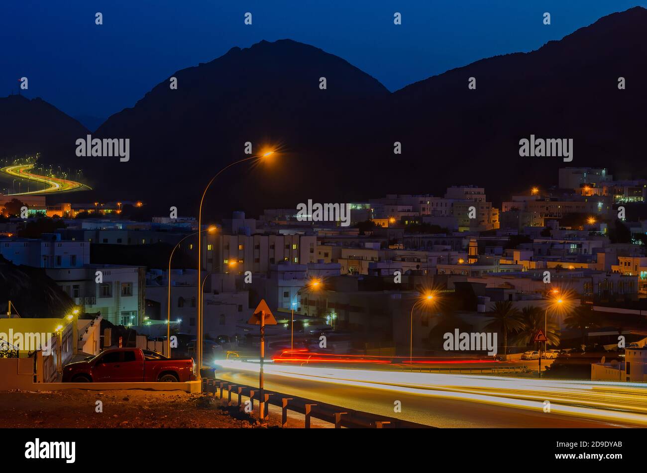 Car Motion Trails in einer ruhigen Nacht in einer kleinen Stadt in Maskat, Oman. Stockfoto