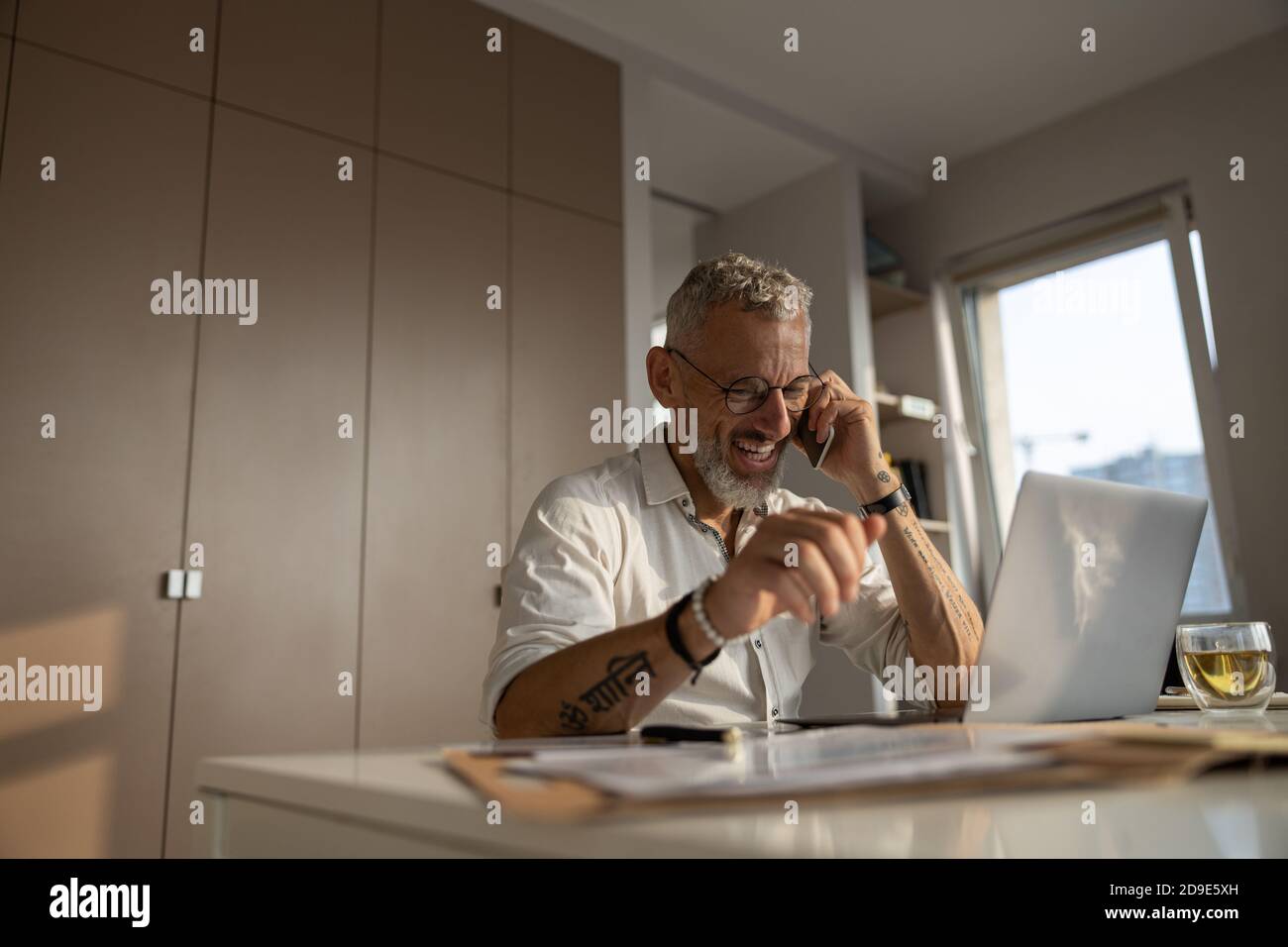 Fröhlicher Unternehmer hat einen geschäftlichen Anruf Stockfoto
