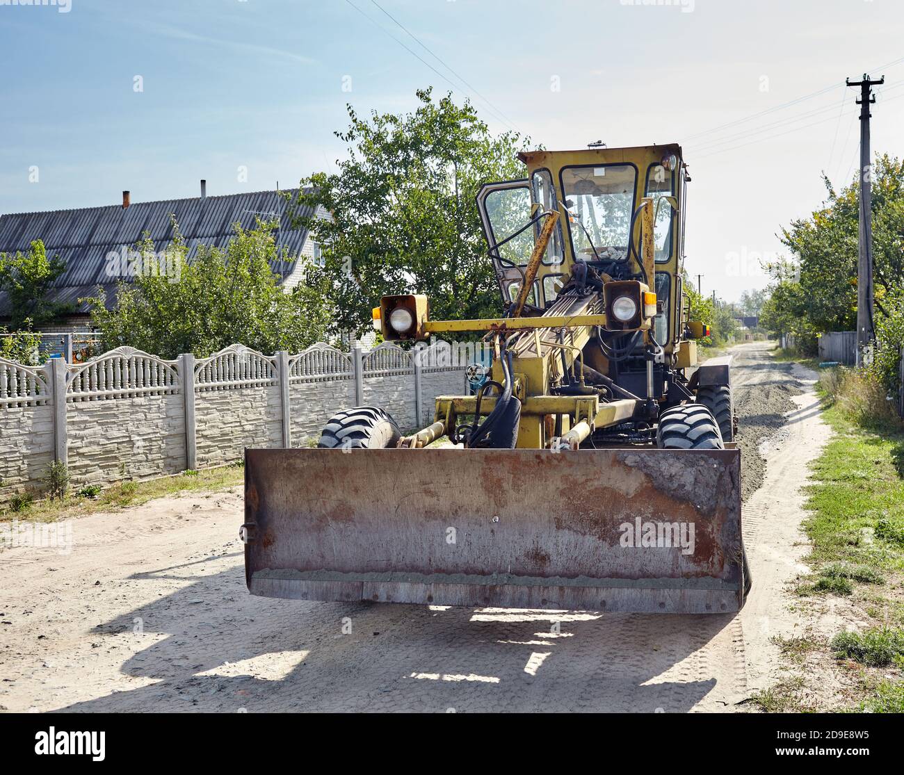 Straßengrader - Schwererde bewegende Straßenbauausrüstung. Industrieller Motorgrader auf dem Boden Stockfoto