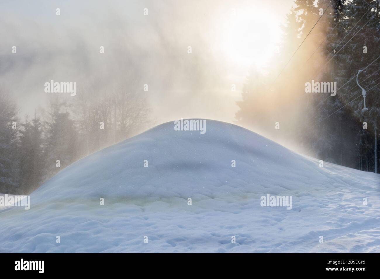 Hintergrundbeleuchtung durch den Schnee Spray aus einer Schneekanone Stockfoto