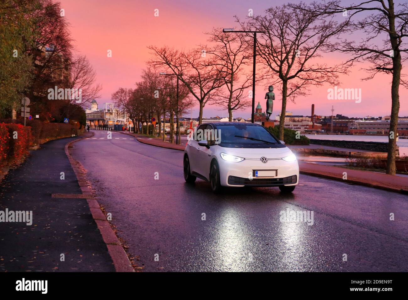 White Volkswagen ID3 Elektroauto fahren auf Küstenstraße in schönen Morgendämmerung, Kopierer Platz. Helsinki, Finnland. November 2020. Stockfoto
