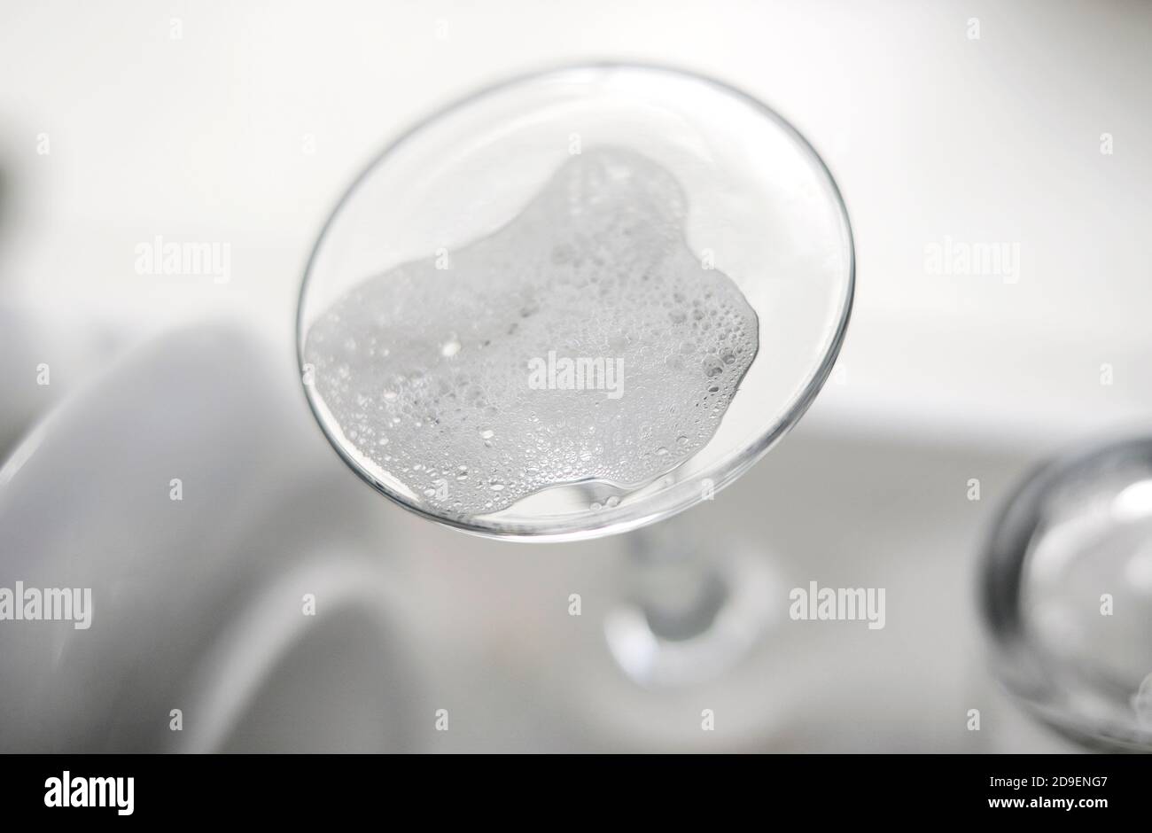 Seifenblasen auf Weinglasboden abwaschen Stockfoto