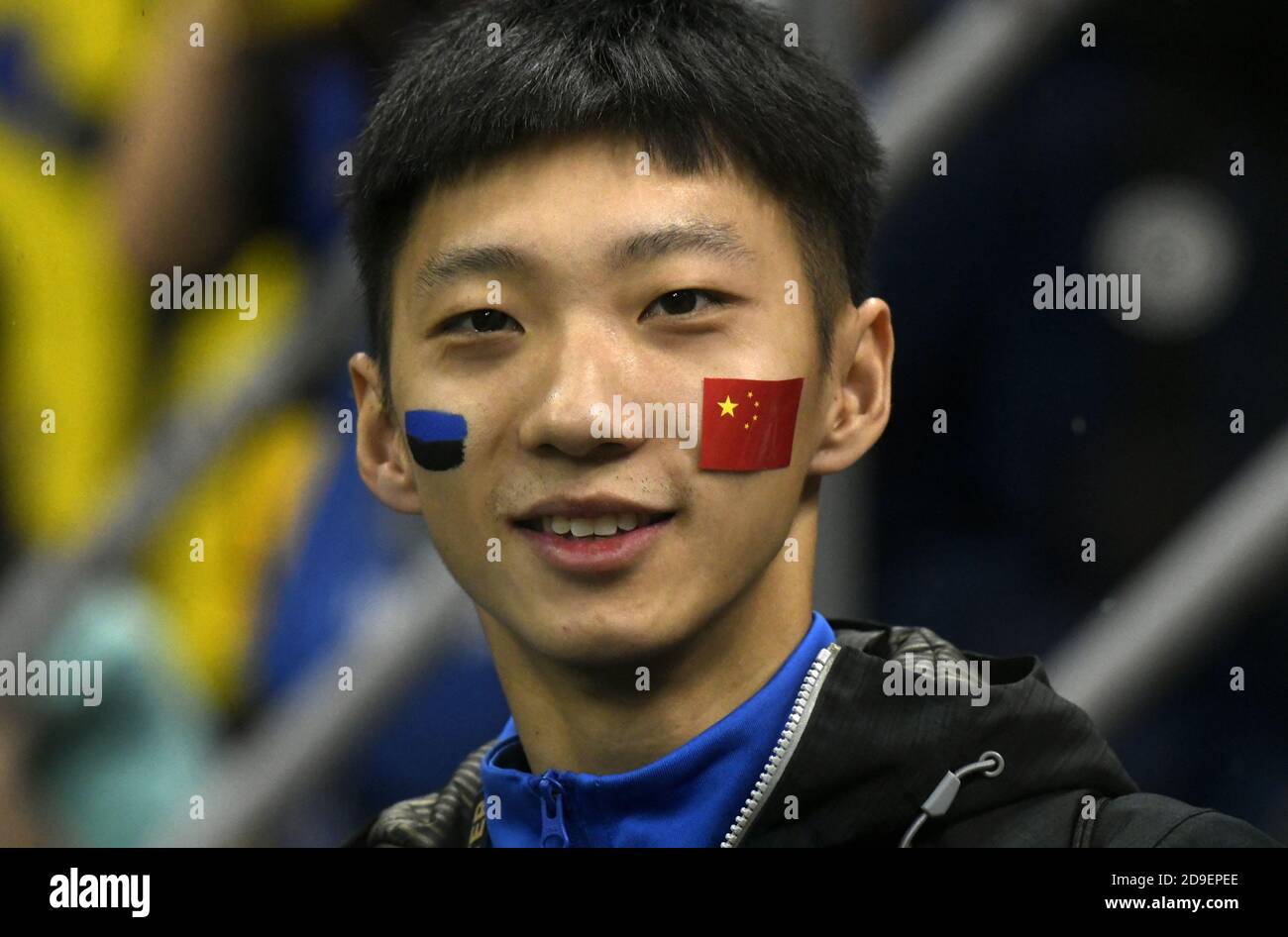 Der Fußballfan des jungen chinesen Inter Mailand, der mit bemalten Flaggen auf seinem Gesicht porträtierte, im fußballstadion san siro in Mailand. Stockfoto