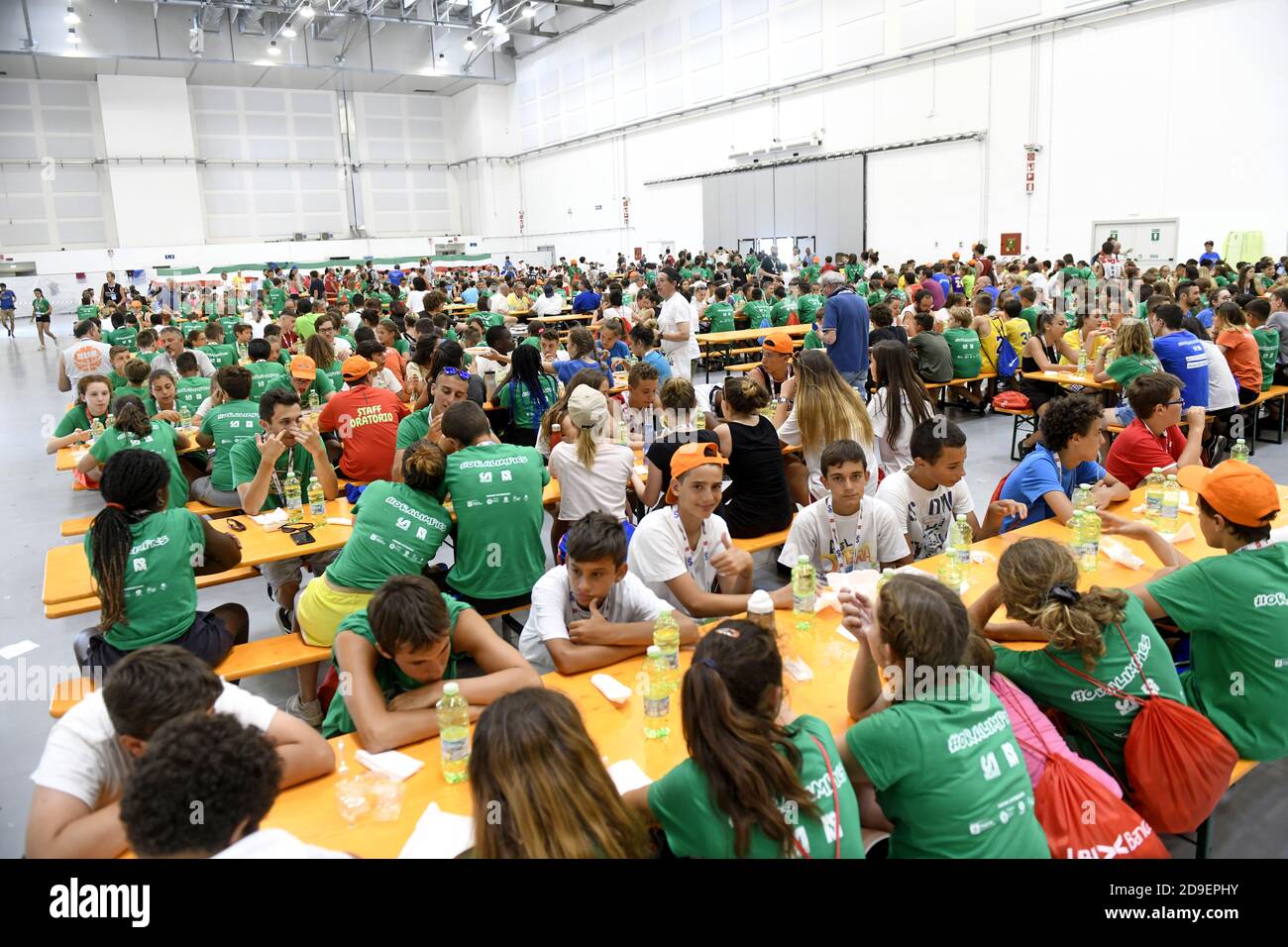 Hunderte von Kindern sitzen für das Mittagessen in einem Sommercamp Kantine , in Mailand. Stockfoto