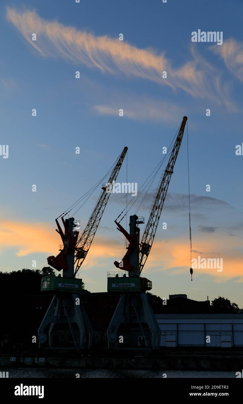 LIEPAJA, LETTLAND - 25. JUN 2017: Liepajas schöner Abend bei Sonnenuntergang. Silhouetten von Hafenkranen Stockfoto