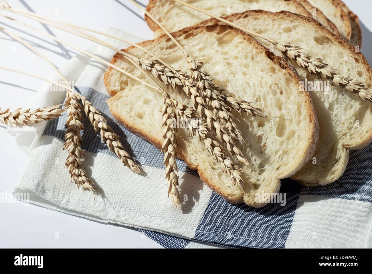 Etwas Stückchen Weizenbrot auf der Küchenserviette mit den Ähren des Weizens. Hausgemachte Ciabatta. Platz für Text kopieren. Stockfoto