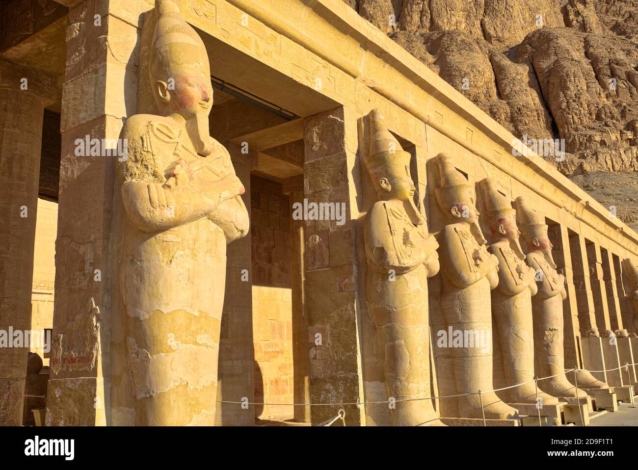 Statuen von Horus, in Falkenform, flankieren die Rampe, die vom zweiten Hof zur dritten Ebene führt. Diese dritte Ebene beherbergt einen Portikus mit Dual Stockfoto
