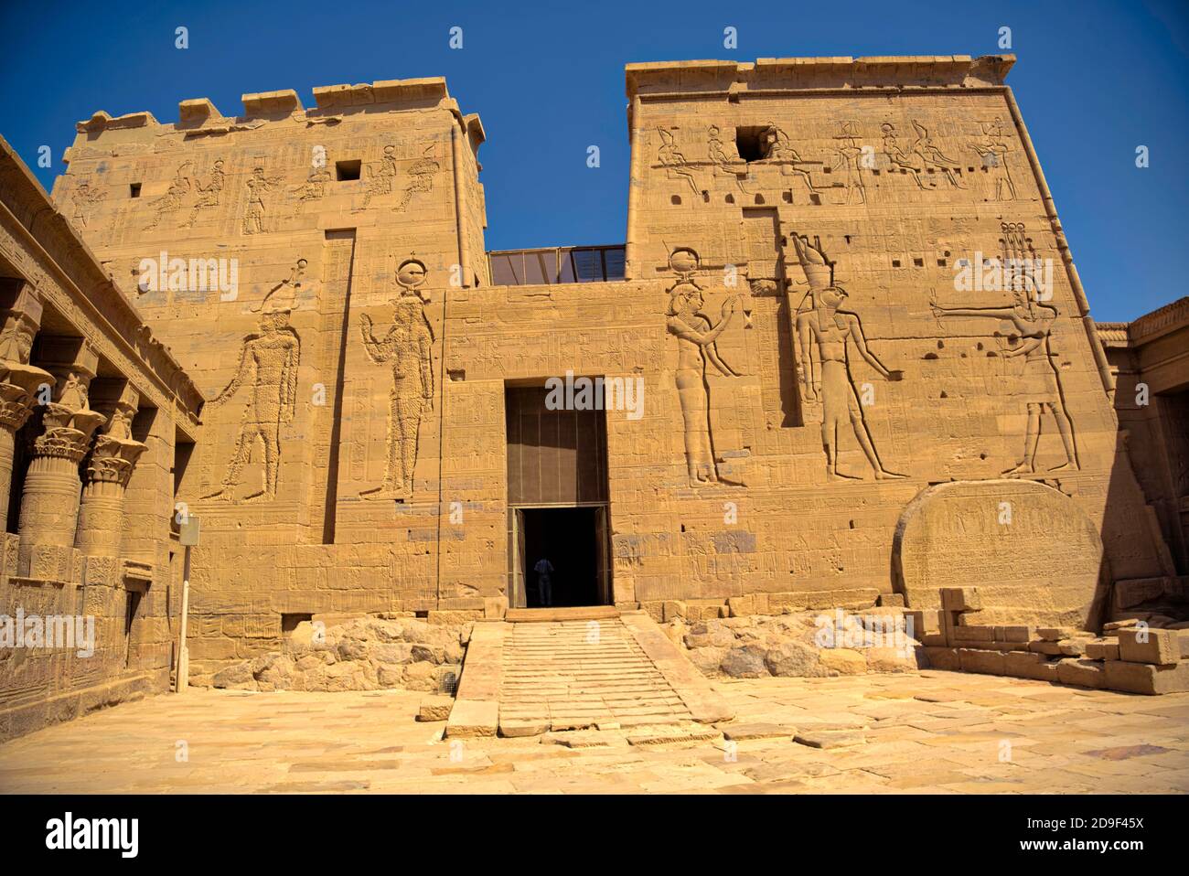 Beide Türme des zweiten Pylons haben Rillen für Fahnenstäbe wie der erste Pylon. Die Tür zwischen den Türmen stellt Ptolemäus VIII. Euergetes dar Stockfoto