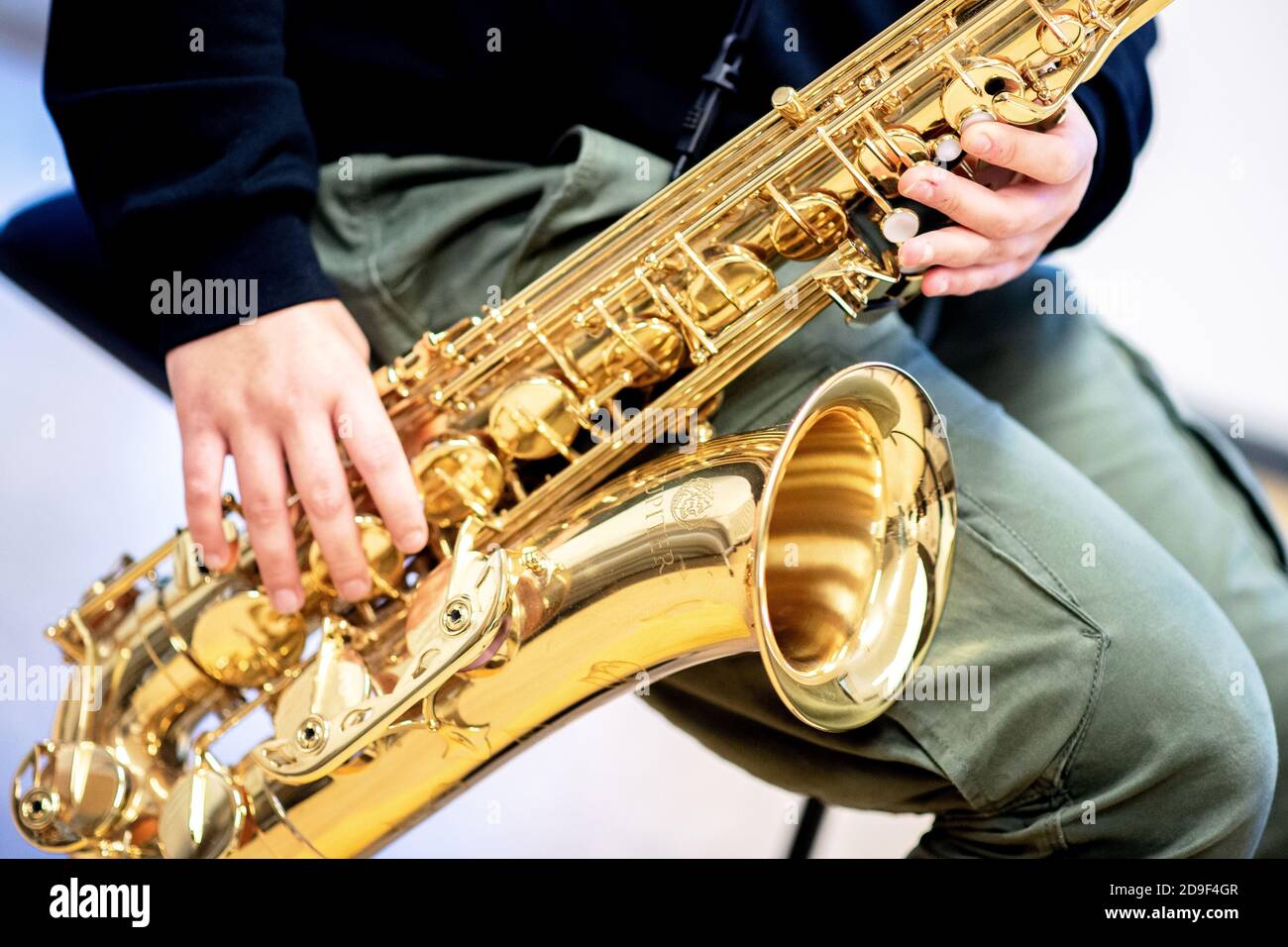 Hannover, Deutschland. November 2020. Eine Musikstudentin spielt ihr Saxophon während eines Unterrichts an der städtischen Musikschule. Die mehr als 70 öffentlichen und gemeinnützigen Musikschulen Niedersachsens können aufgrund ihrer Einstufung als Bildungseinrichtungen trotz der teilweisen Sperrung im November weiterhin geöffnet bleiben. Beim Musizieren müssen Lehrer und Schüler eine Mundschutz tragen. Quelle: Hauke-Christian Dittrich/dpa/Alamy Live News Stockfoto