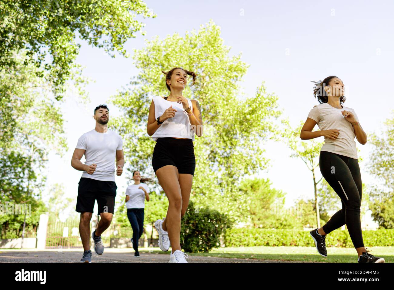 Gruppe von jungen multirassischen glücklichen Menschen tun Joggen in der Morgen im Park - multiethnische Freunde trainieren tagsüber Gemeinsam in der Natur laufen - H Stockfoto