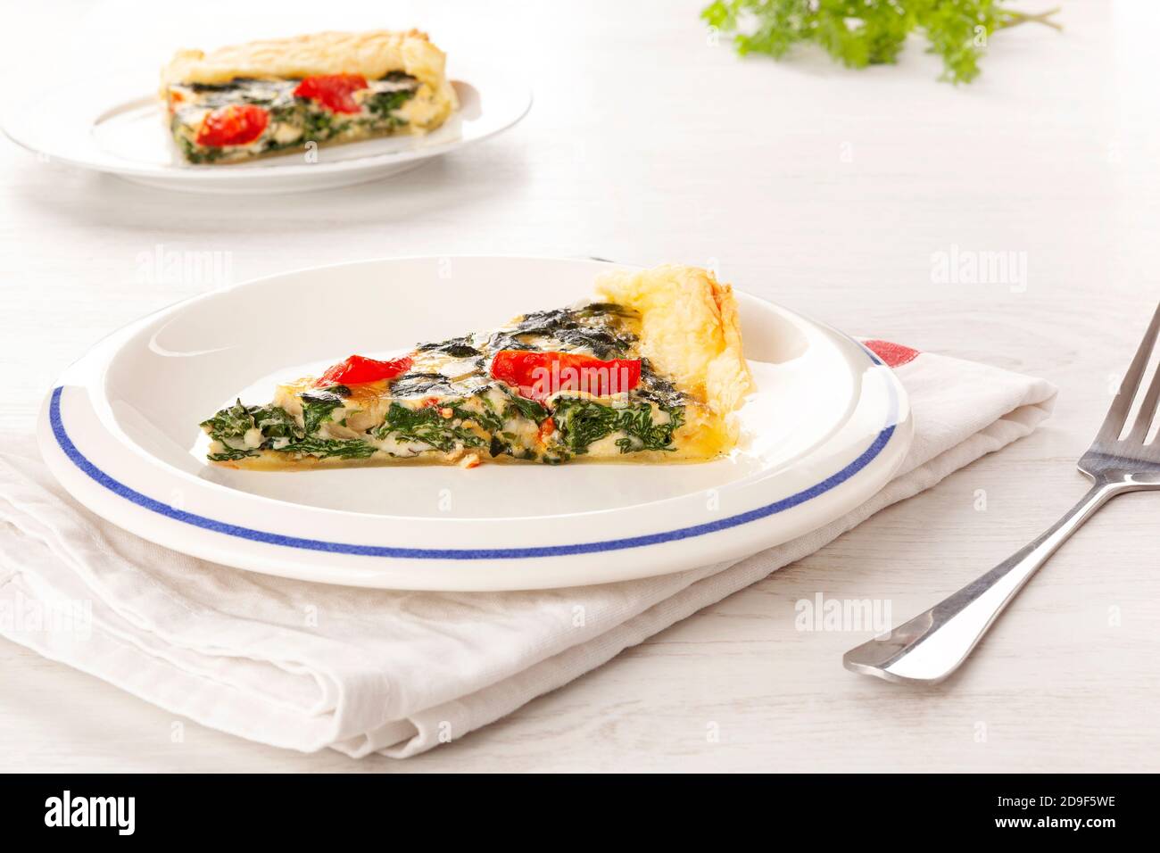 Stück Pie mit Spinat und Tomaten. Vegetarische Küche. Stockfoto