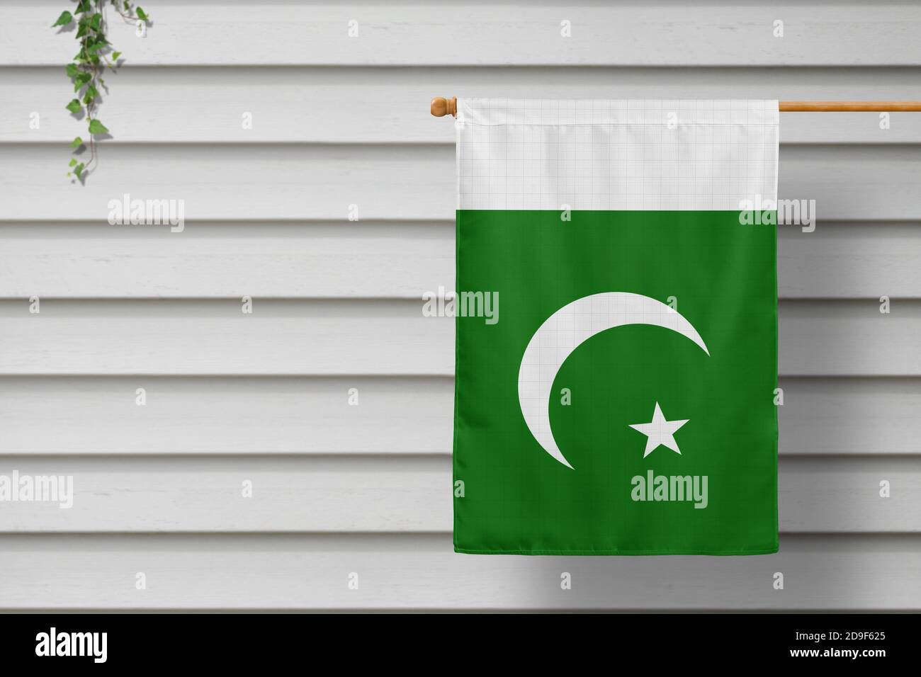 Pakistan nationale kleine Fahne hängt von einem Pfostenzaun entlang der hölzernen Wand in einer ländlichen Stadt. Konzept des Unabhängigkeitstages. Stockfoto