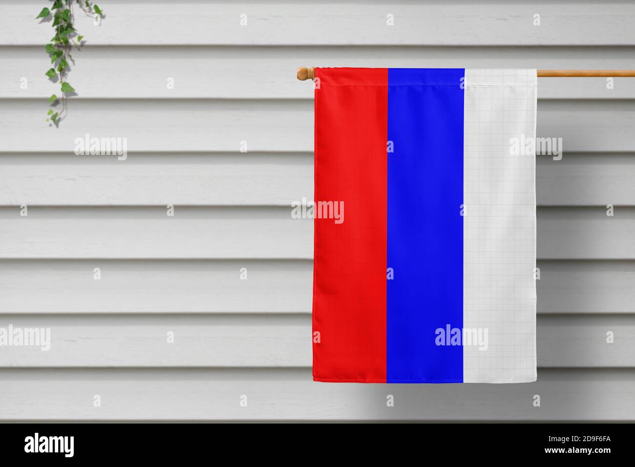 Russland nationale kleine Flagge hängt von einem Pfostenzaun entlang der Holzmauer in einer ländlichen Stadt. Konzept des Unabhängigkeitstages. Stockfoto