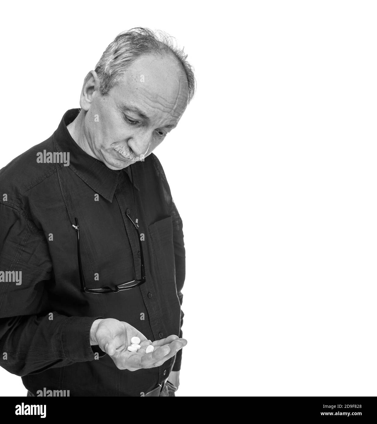 Schwarz-Weiß-Bild eines alten Mannes, der will Nehmen Sie eine Pille isoliert auf weiß mit Kopierraum Stockfoto