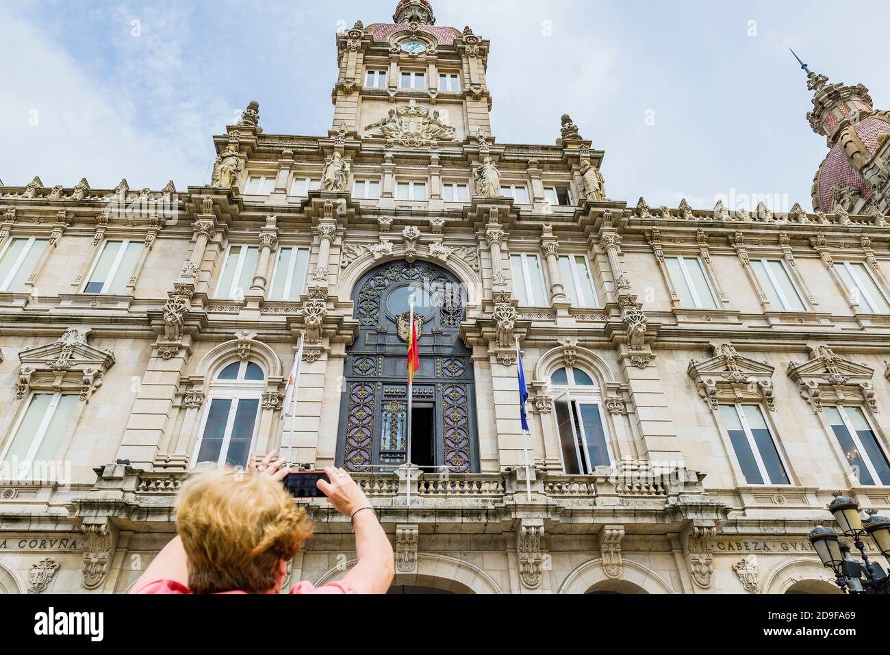 Ein Tourist fotografiert mit seinem Handy das Rathaus von La Coruña. A Coruna, Galicien, Spanien, Europa Stockfoto
