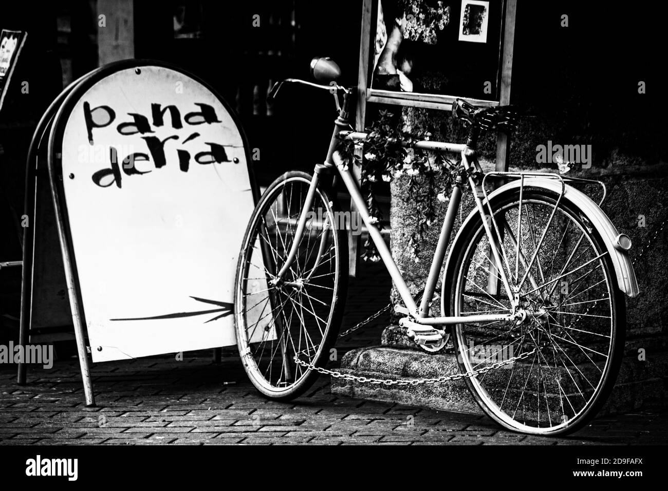 Altes Fahrrad im Zentrum von Burgos in schwarz und Weiß mit einem Backwarenschild Stockfoto