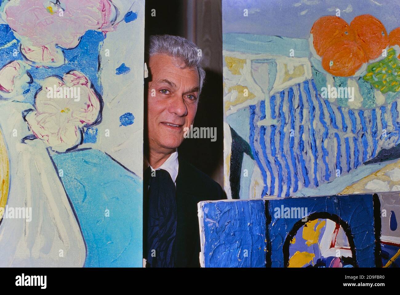 Hollywood-Legende Tony Curtis (3. Juni 1925 – 29. September 2010) posiert mit einer Auswahl seiner Gemälde. Mayfair Hotel, London, England, Großbritannien um 1980 Stockfoto