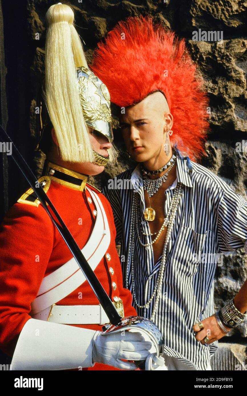 Punk Rocker Matt Belgrano, 'The Postcard Punk' steht mit einem Mitglied der Household Cavalry, Horse Guards Parade, London, England, UK, um 1980 Stockfoto