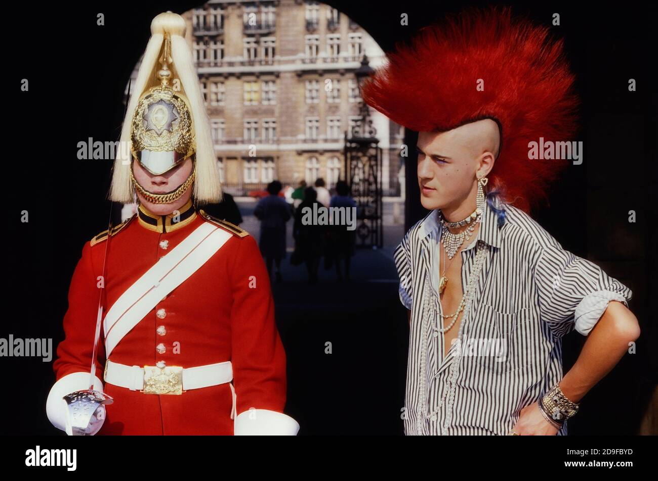 Punk Rocker Matt Belgrano, 'The Postcard Punk' steht mit einem Mitglied der Household Cavalry, Horse Guards Parade, London, England, UK, um 1980 Stockfoto