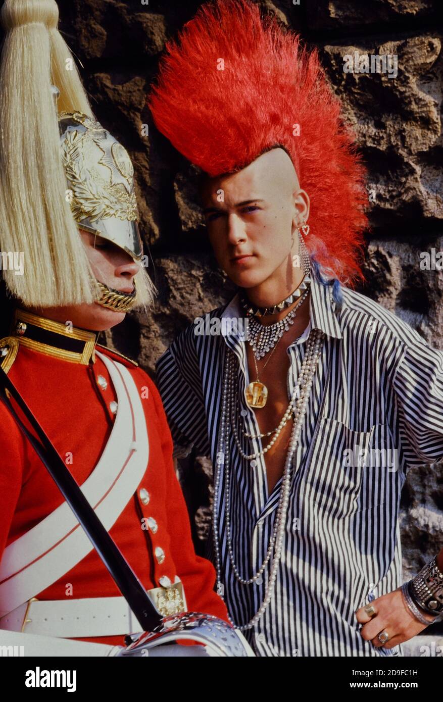 Punk Rocker Matt Belgrano, 'The Postcard Punk' steht mit einem Mitglied der Household Cavalry, Horse Guards Parade, London, England, UK, um 1980 Stockfoto