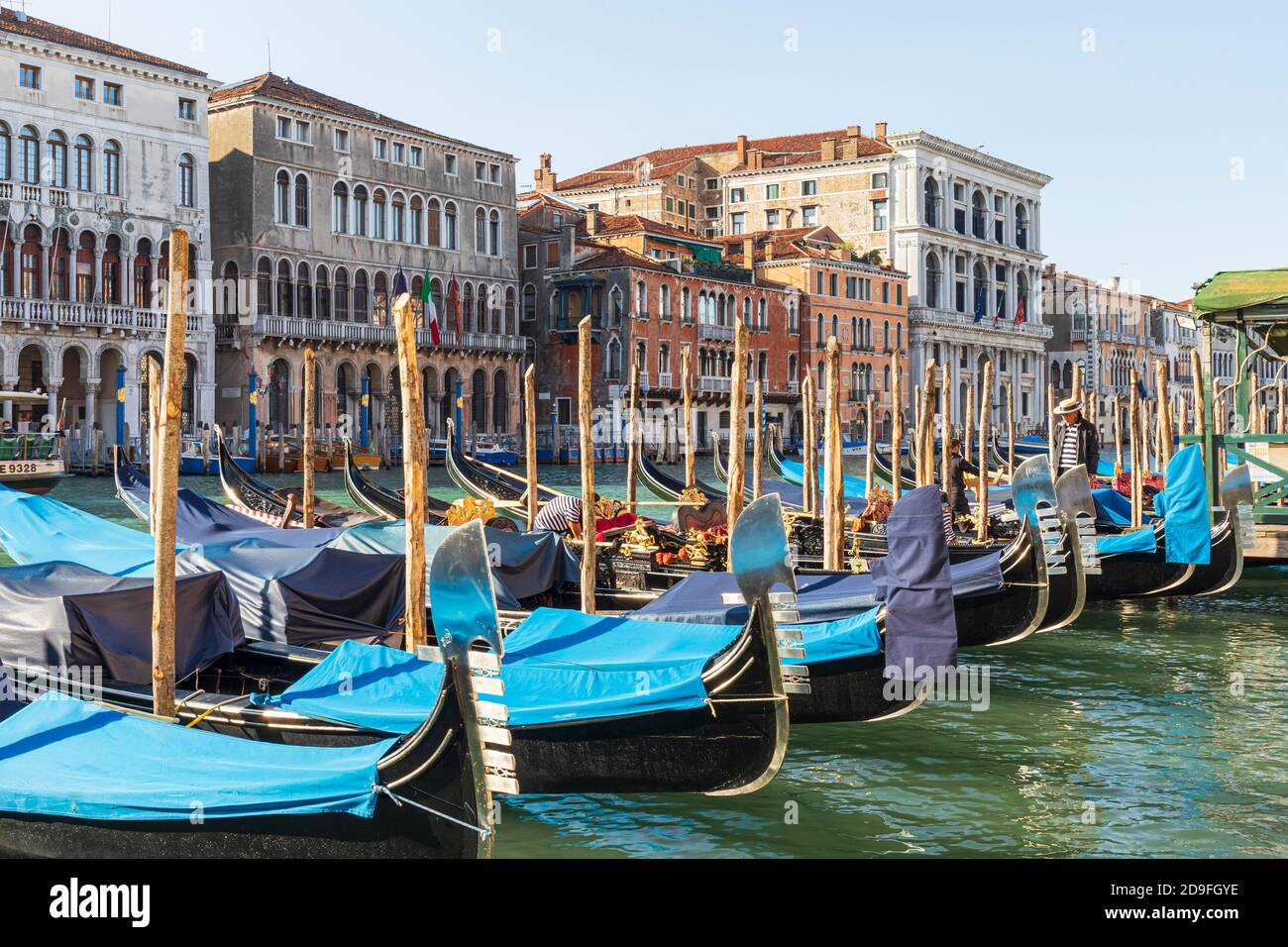 Traditionelle italienische Architektur am Canale Grande in Venedig mit Gondola (Gondoliere), die mit blauen Abdeckungen vertäut ist. September 2020, Venedig, Italien Stockfoto