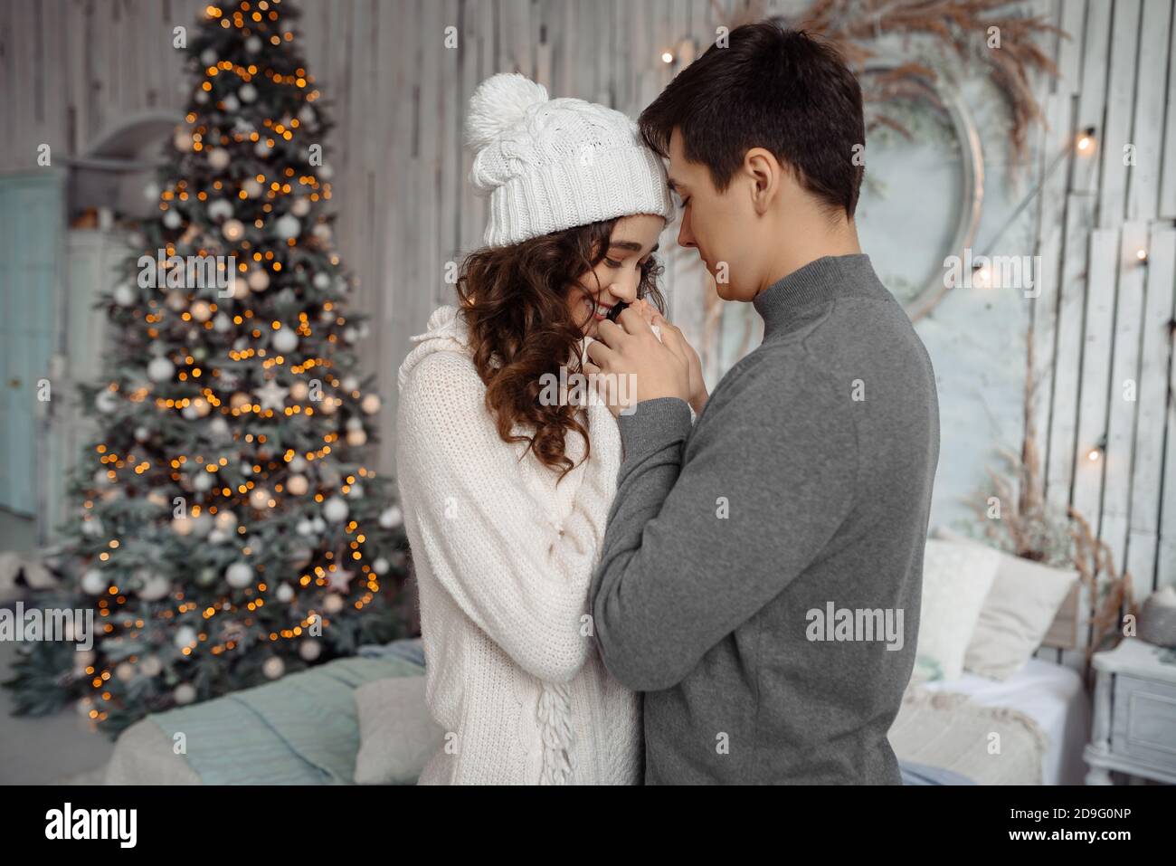 Glückliches junges reizendes Paar genießt einander an Silvester in einer gemütlichen häuslichen Umgebung. Liebesgeschichte des neuen Jahres. Stockfoto