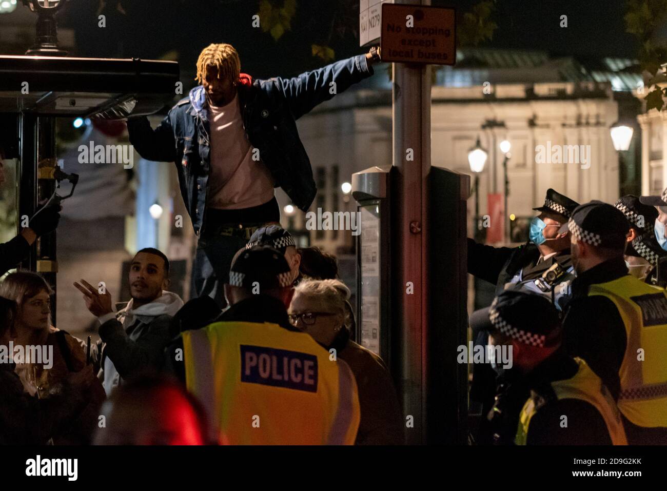 Westminster, London, Großbritannien. November 2020. Am 5. November fand in der Nähe des Parlaments ein regierungsfeindlicher Protest statt, der sich mit dem Schießpulver-Komplott von 1605 und dem Versuch, das Gebäude zu zerstören, verband. Da das Datum auch der erste Tag der nationalen Sperre ist, haben sich Anti-Lockdown-Demonstranten angeschlossen. Eine starke Polizeipräsenz reduzierte die Auswirkungen des Ereignisses, das sich vor dem Trafalgar Square versammelt hatte. Schwarzer Mann, umgeben von Polizei Stockfoto