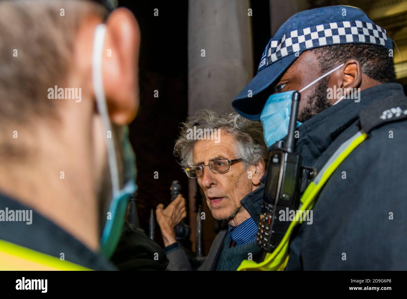London, Großbritannien. November 2020. Piers Corbyn spricht und wird gebeten, mit einer Polizeieskorte zu gehen, was er tut. Ein paar hundert Menschen kommen auf - und werden schnell von der Polizei aufgefordert, weiter zu gehen - der jährliche Million Mask Protest und die V for Freedom Rallye in London werden mit der Covid-Falschmeldung, aufstehen aufstehen Protestbewegung gefangen. Kredit: Guy Bell/Alamy Live Nachrichten Stockfoto