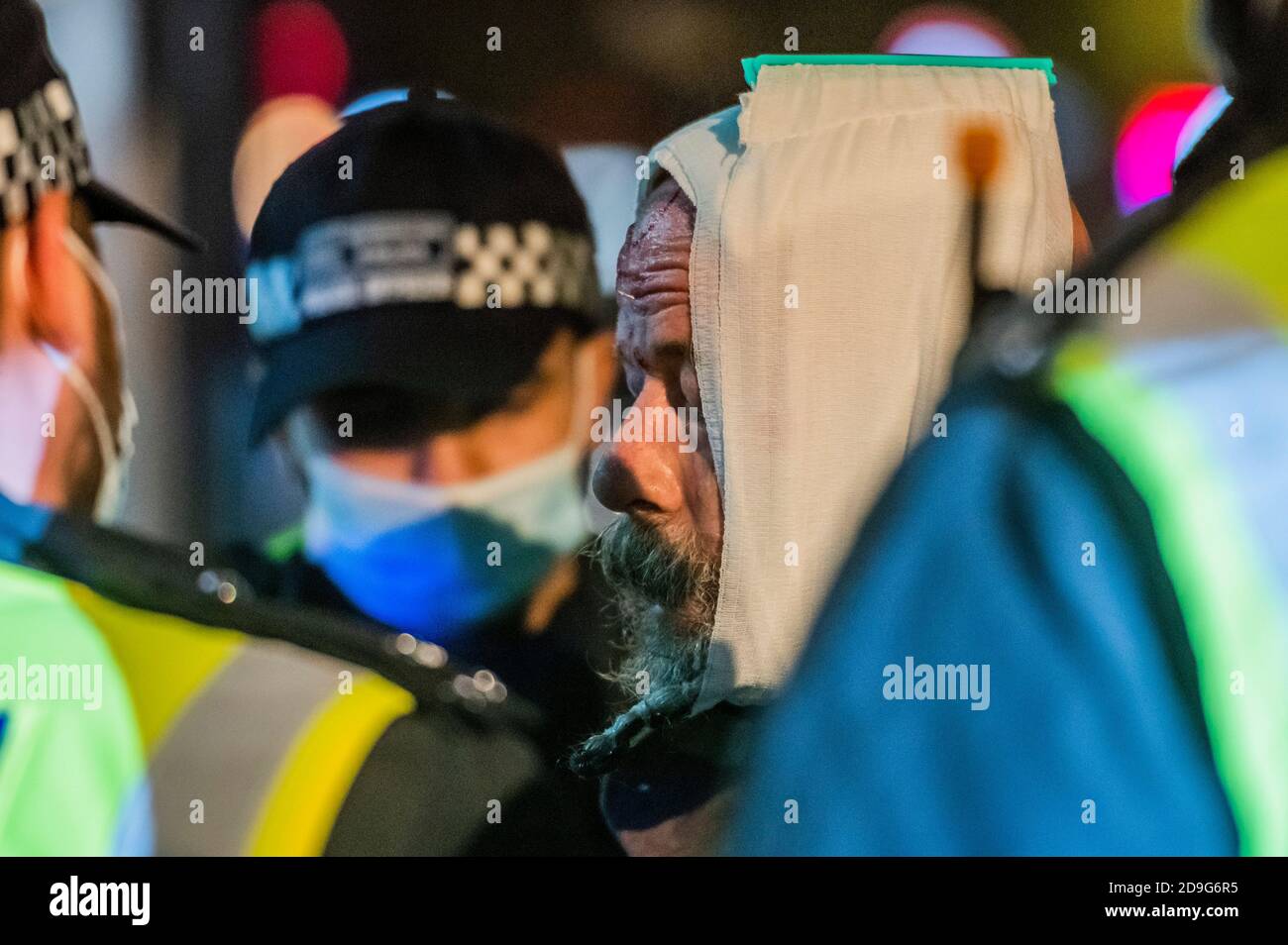 London, Großbritannien. November 2020. Ein Mann wird verhaftet und bekommt im Handgemenge eine Kopfverletzung. Er wird von einem Polizeimediziner und dann von einer Rettungsmannschaft behandelt. Ein paar hundert Menschen kommen auf - und werden schnell von der Polizei aufgefordert, weiter zu gehen - der jährliche Million Mask Protest und die V for Freedom Rallye in London werden mit der Covid-Falschmeldung, aufstehen aufstehen Protestbewegung gefangen. Kredit: Guy Bell/Alamy Live Nachrichten Stockfoto