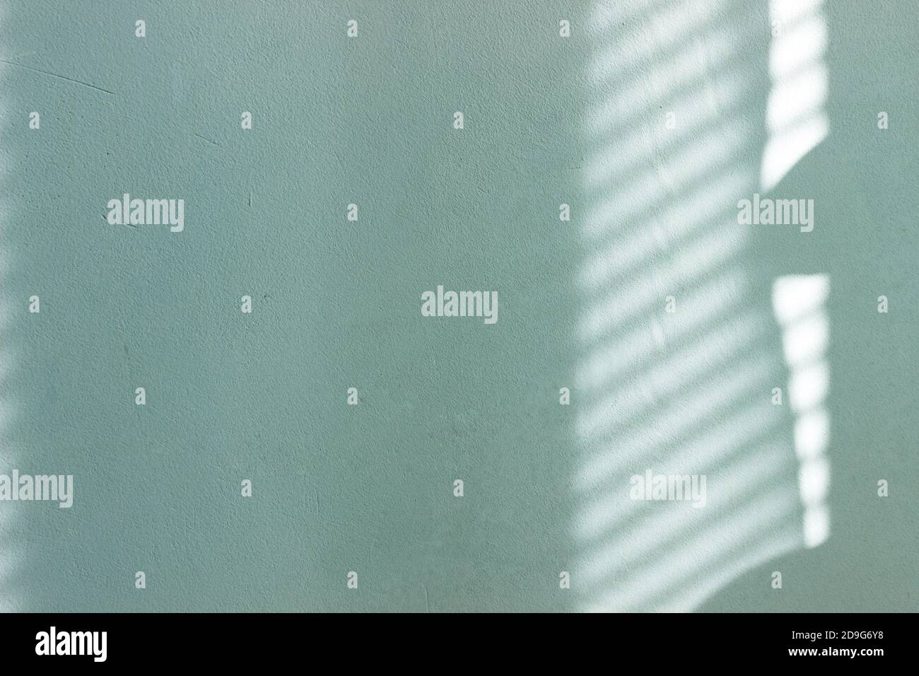 Kontrastierende Schatten auf einer sonnenbeschienenen bemalten Wand. Stockfoto