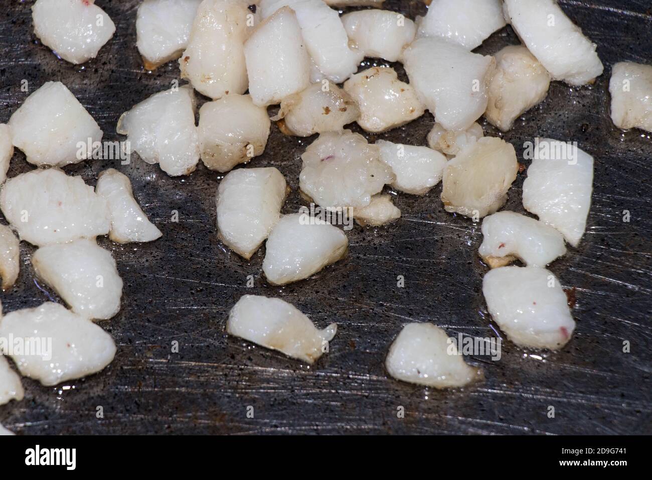 Braten eines Hammelschwanzfetts in einer Eisenpfanne. Fettige Mahlzeiten Stockfoto