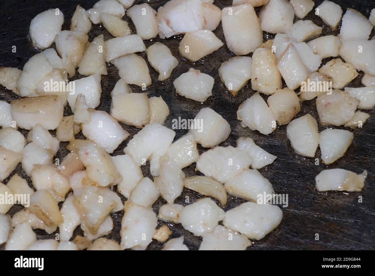 Braten eines Hammelschwanzfetts in einer Eisenpfanne. Fettige Mahlzeiten Stockfoto