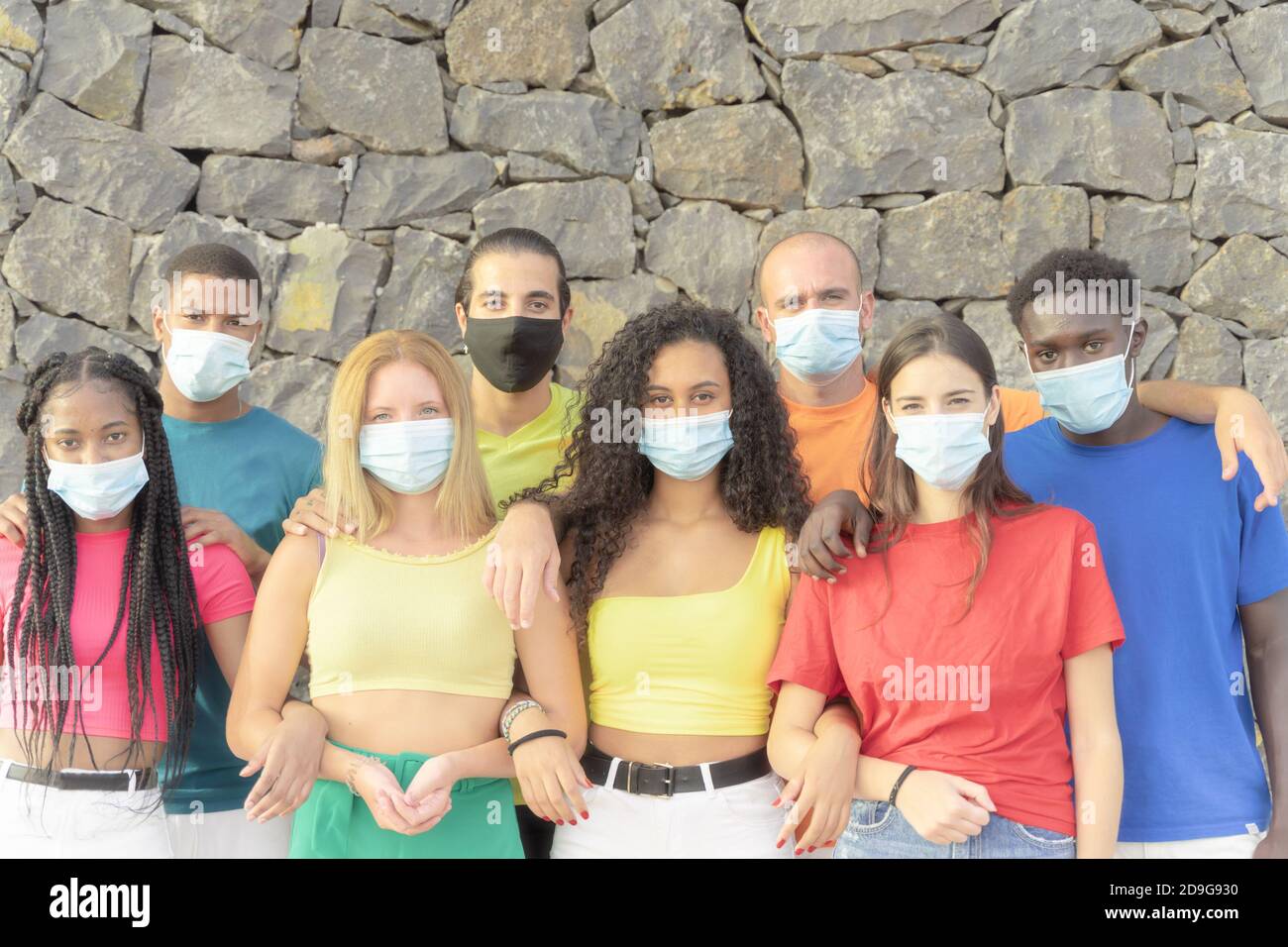 Millennial Menschen aus verschiedenen Kulturen und Rassen Blick auf Kamera mit Schutzmasken für Coronavirus . Studenten haben Spaß an der erasmus-Universität. Stockfoto