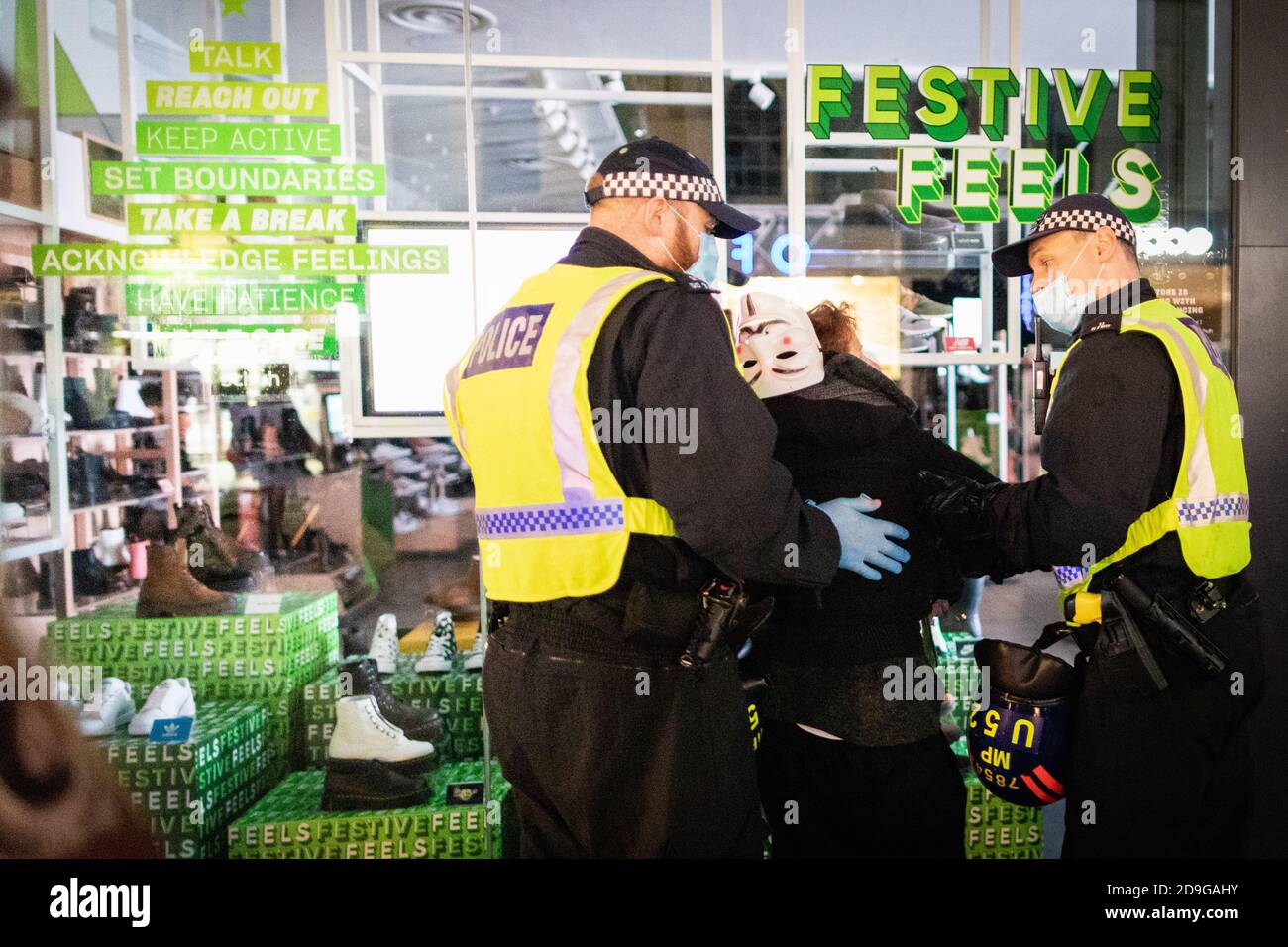 London, Großbritannien. November 2020. Eine Frau wird von der Polizei festgenommen, als Demonstranten die Oxford Road entlang marschieren. Die expect US Bewegung nimmt an ihrem jährlichen Million Mask March Teil. Die Anonymous-Bewegung zeigt Solidarität für eine Gesellschaft, die von der politischen Elite und den assoziierten Unternehmen marginalisiert wird. Kredit: Andy Barton/Alamy Live Nachrichten Stockfoto