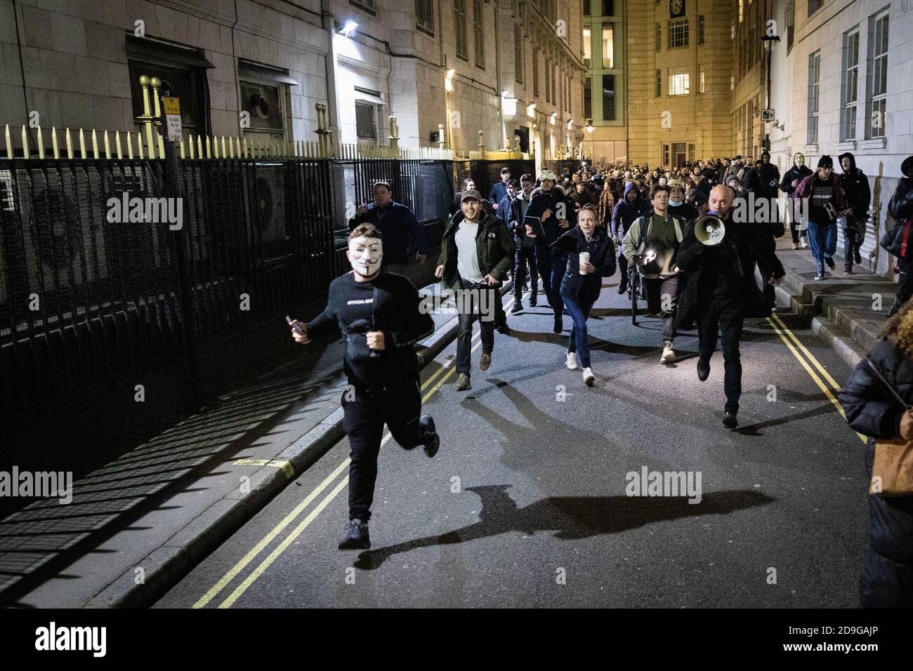 London, Großbritannien. November 2020. Demonstranten laufen als MET Polizeianschlag in einem Versuch, den marsch zu zerstreuen. Die expect US Bewegung nimmt an ihrem jährlichen Million Mask March Teil. Die Anonymous-Bewegung zeigt Solidarität für eine Gesellschaft, die von der politischen Elite und den assoziierten Unternehmen marginalisiert wird. Kredit: Andy Barton/Alamy Live Nachrichten Stockfoto