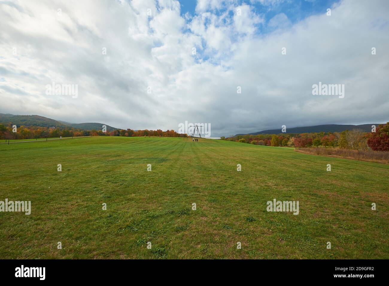 Spaziergang durch die südlichen Felder mit Mark di Suveros Pyramidian Skulptur auf dem Hügel. Während des Herbstes ist die Herbstfärbung im Storm King Art Center in New York am höchsten. Stockfoto